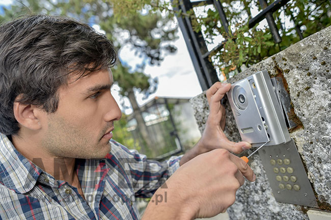 człowiek montujący system interkomowy