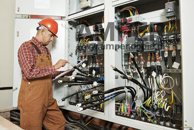 elektryk sprawdzający połączenia w rozdzielni elektrycznej